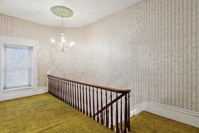 stairway featuring a chandelier and carpet flooring