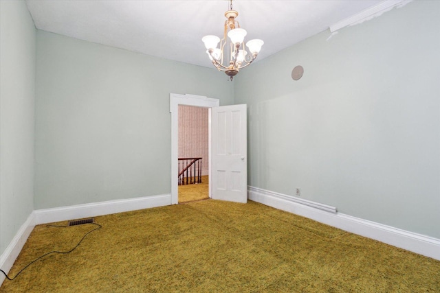 carpeted spare room featuring a notable chandelier