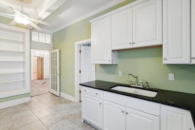 kitchen with sink, ceiling fan, light tile patterned floors, ornamental molding, and white cabinetry