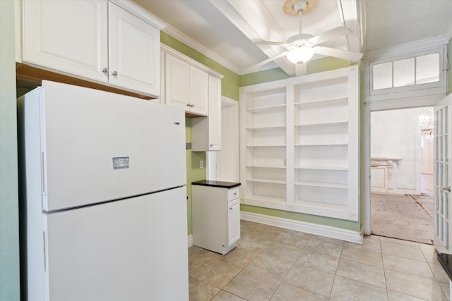 kitchen with white refrigerator, crown molding, ceiling fan, light tile patterned floors, and white cabinetry