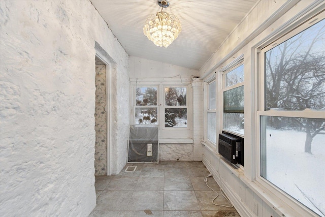 unfurnished sunroom featuring a wealth of natural light, cooling unit, vaulted ceiling, and a notable chandelier