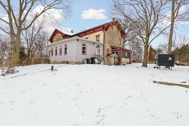 view of snow covered back of property