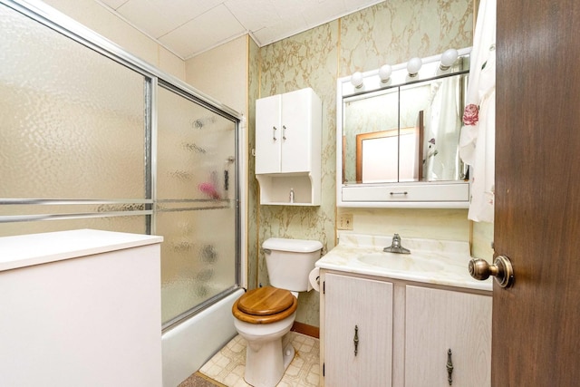 full bathroom featuring vanity, shower / bath combination with glass door, and toilet