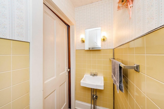 bathroom with decorative backsplash and tile walls