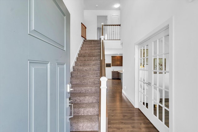 stairway with hardwood / wood-style floors and french doors