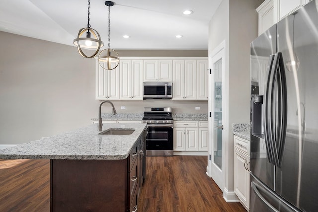 kitchen with light stone countertops, sink, white cabinetry, and stainless steel appliances