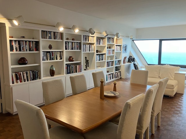 dining room featuring a water view and parquet floors