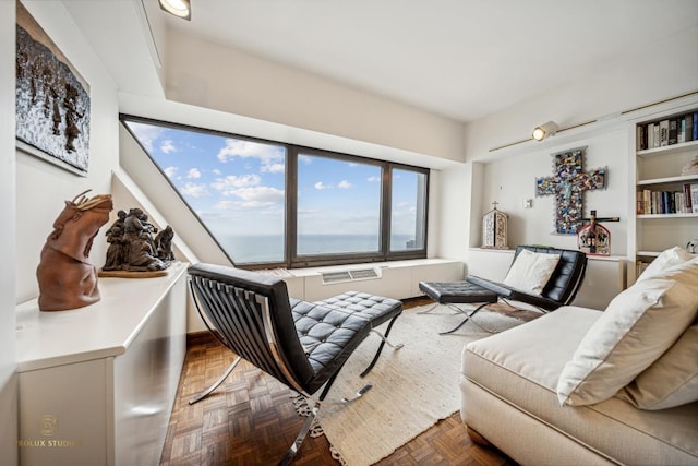 living room featuring dark parquet flooring and a water view