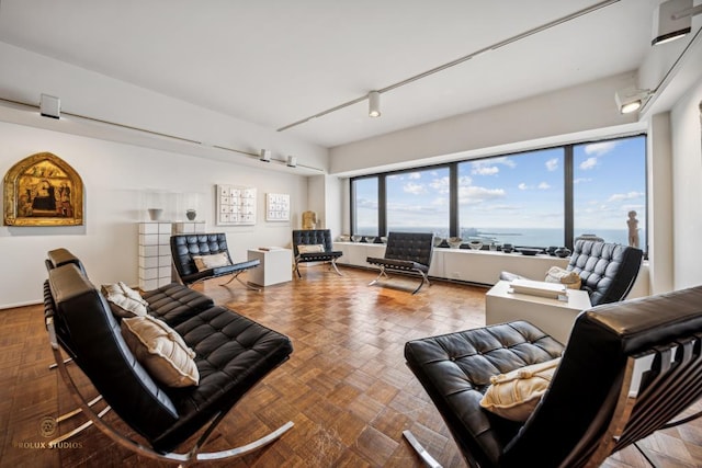 living room featuring a water view and parquet flooring