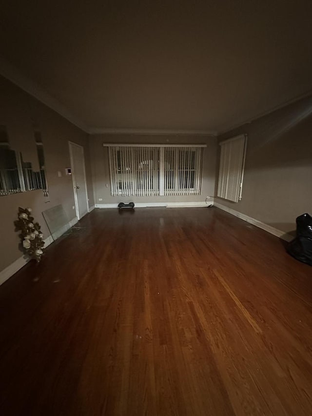 unfurnished living room featuring crown molding and dark hardwood / wood-style floors