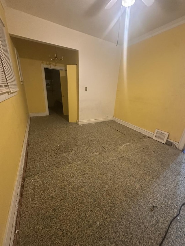 unfurnished room featuring ceiling fan and ornamental molding