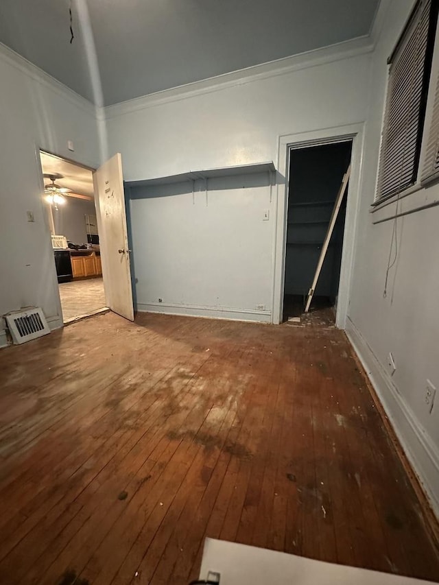 interior space featuring ceiling fan, hardwood / wood-style floors, and crown molding