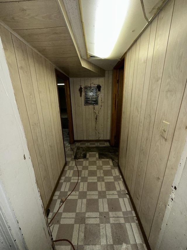 hallway featuring wood walls