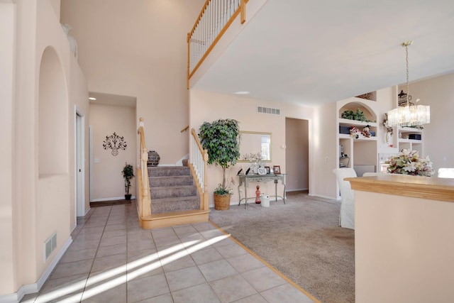 carpeted entryway featuring a chandelier