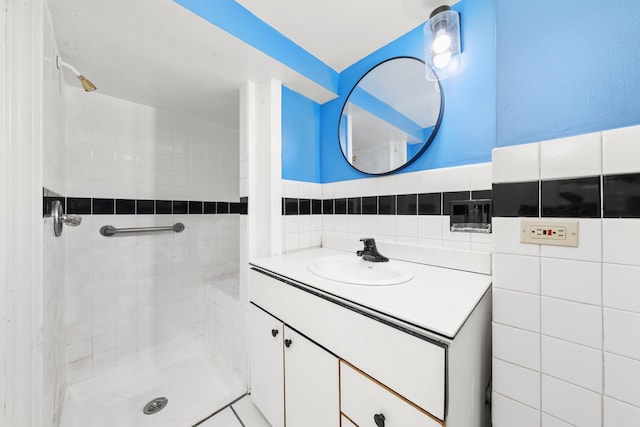 bathroom featuring a tile shower, vanity, and tile walls