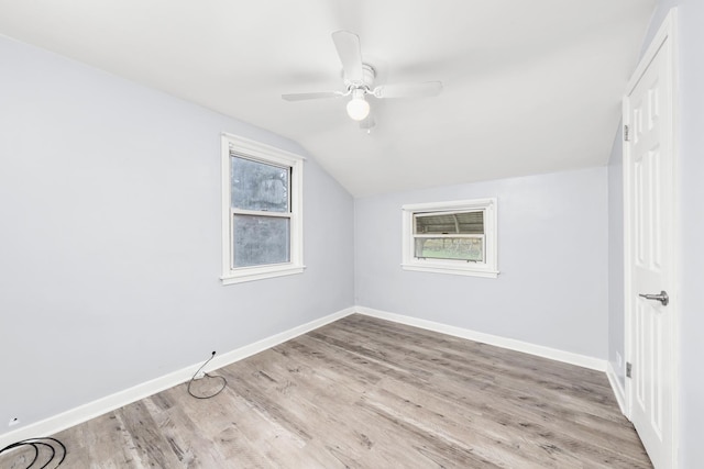 additional living space with ceiling fan, light wood-type flooring, and vaulted ceiling