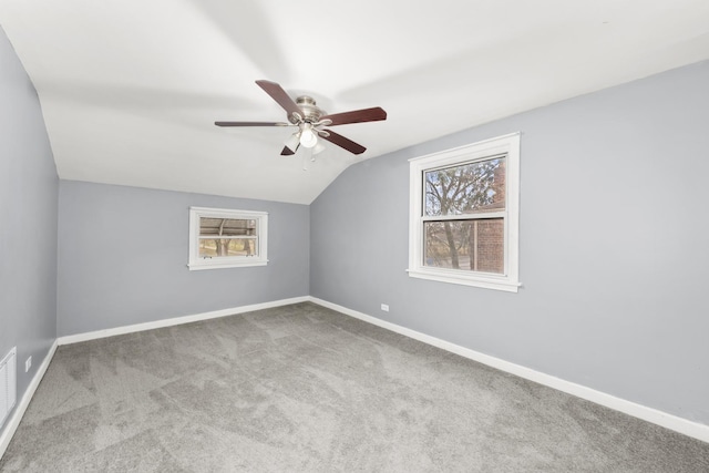 bonus room featuring ceiling fan, light colored carpet, a healthy amount of sunlight, and lofted ceiling