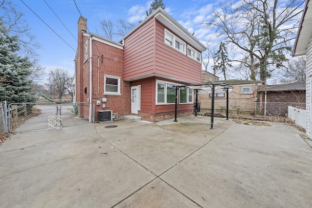 rear view of property featuring a pergola, a patio, and central AC unit