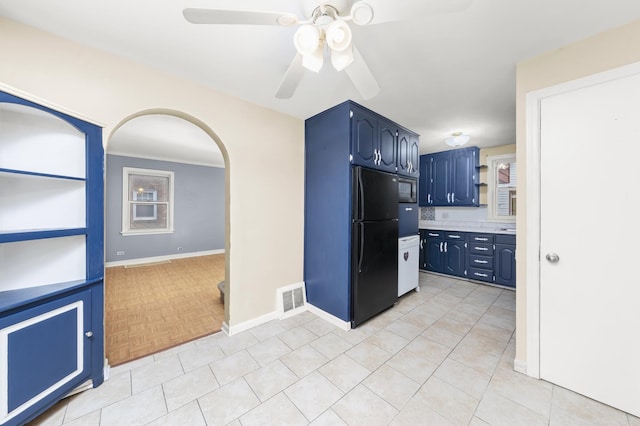 kitchen with ceiling fan, black fridge, light tile patterned floors, and blue cabinetry