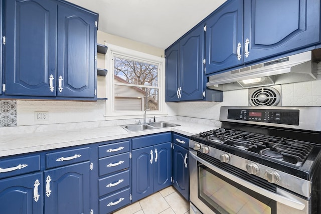 kitchen with backsplash, sink, stainless steel gas stove, light tile patterned floors, and blue cabinetry