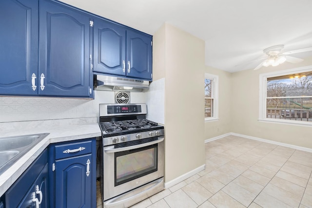 kitchen featuring blue cabinets, sink, stainless steel gas stove, ceiling fan, and light tile patterned floors