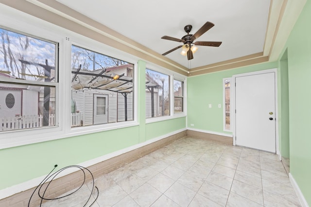 unfurnished sunroom featuring ceiling fan