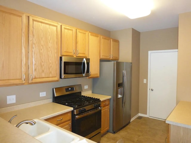 kitchen with sink, stainless steel appliances, and light brown cabinetry