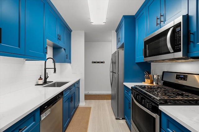 kitchen featuring light hardwood / wood-style flooring, stainless steel appliances, blue cabinets, and sink