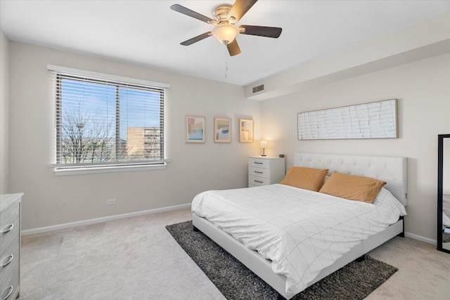 bedroom featuring ceiling fan, light carpet, and multiple windows