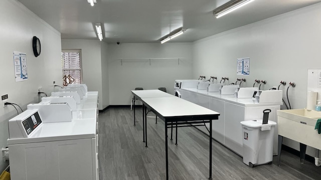 clothes washing area with hardwood / wood-style flooring, ornamental molding, and washing machine and clothes dryer