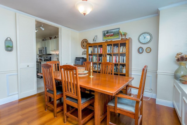 dining area featuring hardwood / wood-style flooring and ornamental molding