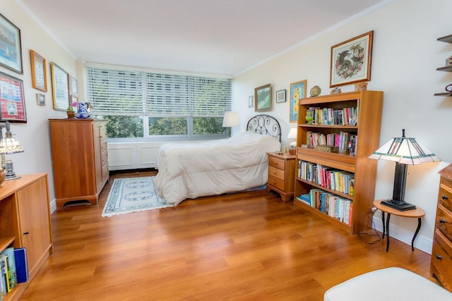 bedroom with light wood-type flooring and ornamental molding