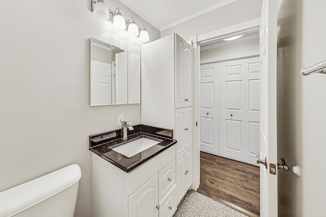 bathroom with vanity, toilet, and ornamental molding