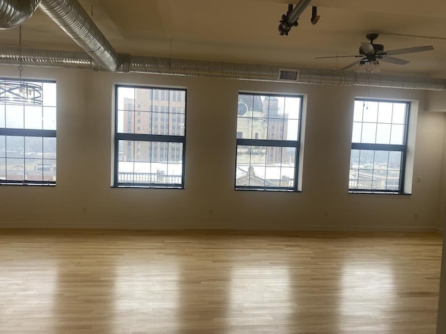 empty room with plenty of natural light, visible vents, and light wood finished floors