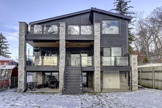 snow covered house featuring a balcony