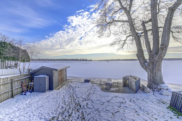 view of yard featuring a water view and a storage shed