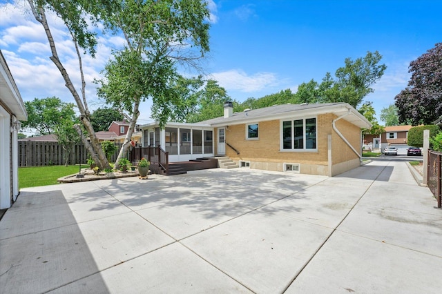 rear view of house with a patio and a sunroom