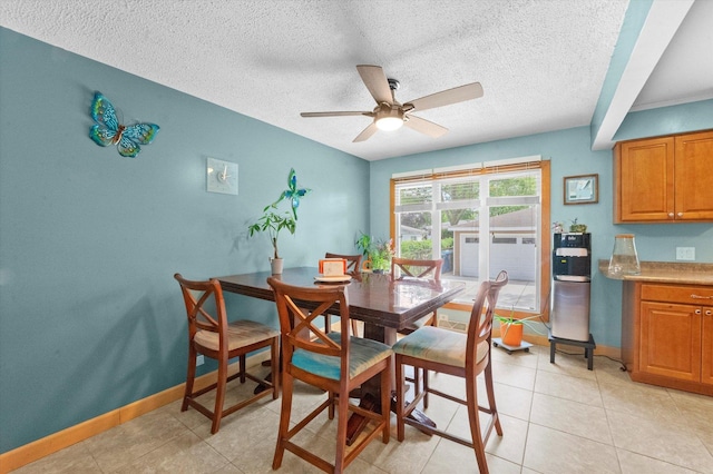 tiled dining area with ceiling fan and a textured ceiling