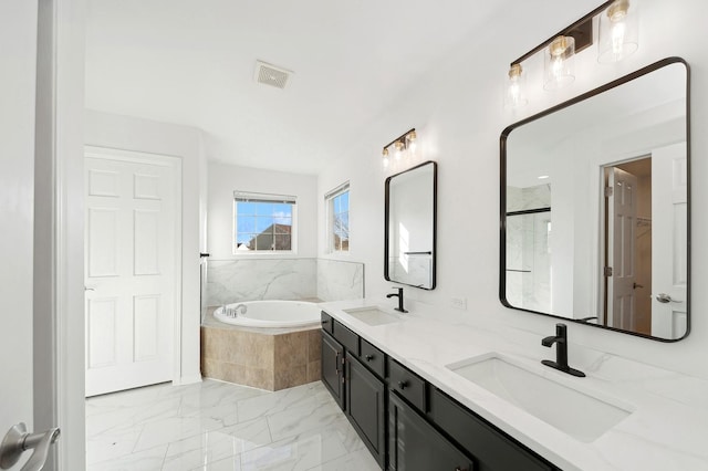 bathroom featuring vanity and independent shower and bath