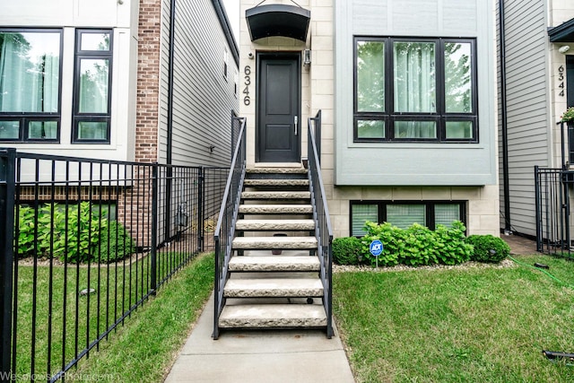 view of exterior entry with a lawn