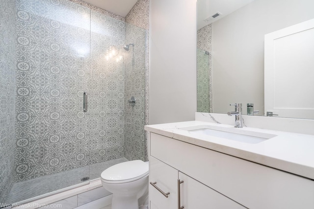 bathroom with tile patterned floors, vanity, toilet, and a shower with shower door