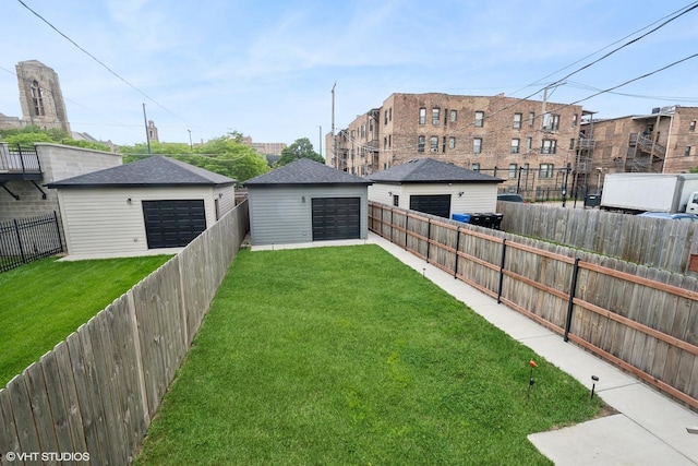 view of yard featuring a garage and an outbuilding