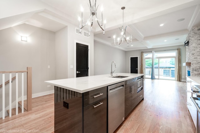 kitchen with dark brown cabinetry, sink, an island with sink, a chandelier, and appliances with stainless steel finishes