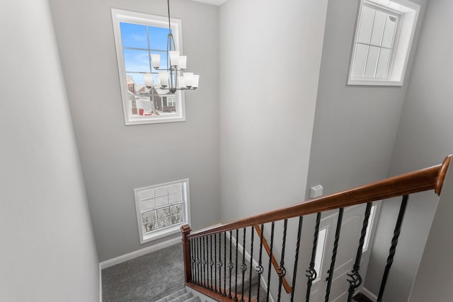 stairs featuring carpet floors and an inviting chandelier