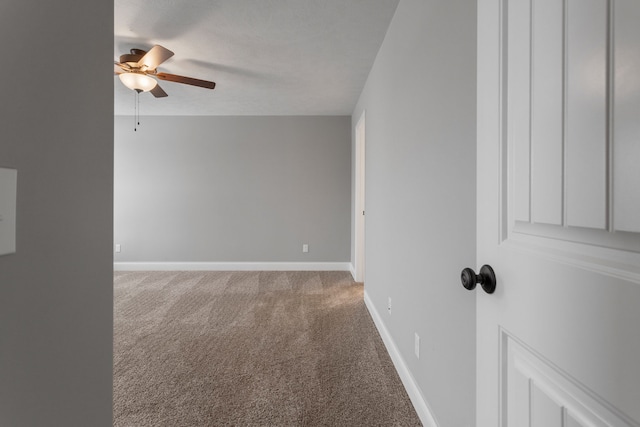 carpeted empty room with ceiling fan and a textured ceiling