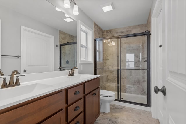 bathroom with vanity, toilet, and a shower with shower door