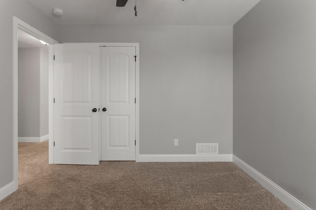 unfurnished bedroom with carpet flooring, ceiling fan, and a closet