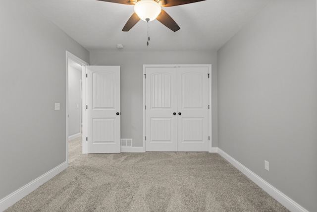 unfurnished bedroom with ceiling fan, carpet floors, and a closet