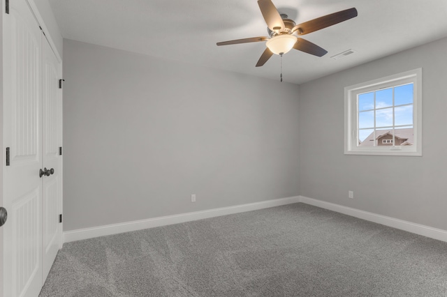 carpeted spare room featuring ceiling fan