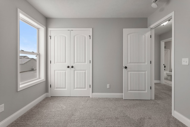 unfurnished bedroom with light colored carpet and a closet